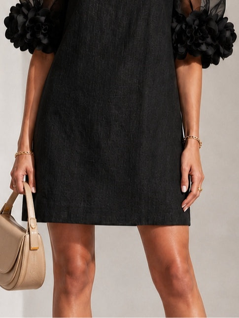Mini vestido negro de organza con mangas abullonadas y puños florales